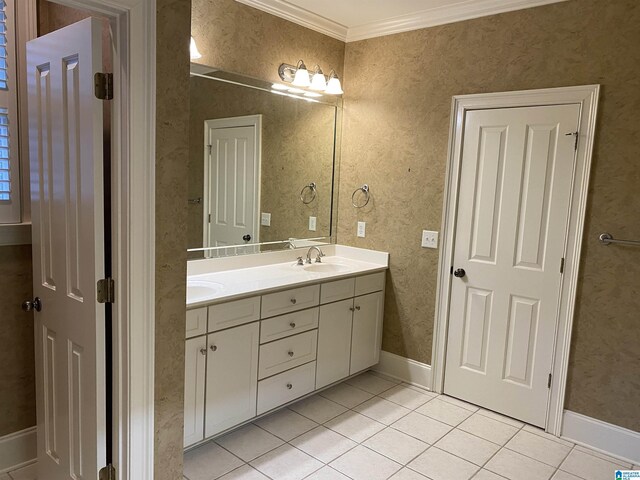 bathroom with crown molding, double vanity, a sink, tile patterned flooring, and wallpapered walls