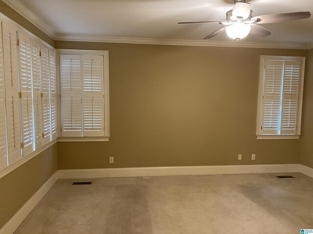 carpeted empty room featuring visible vents, ornamental molding, and baseboards