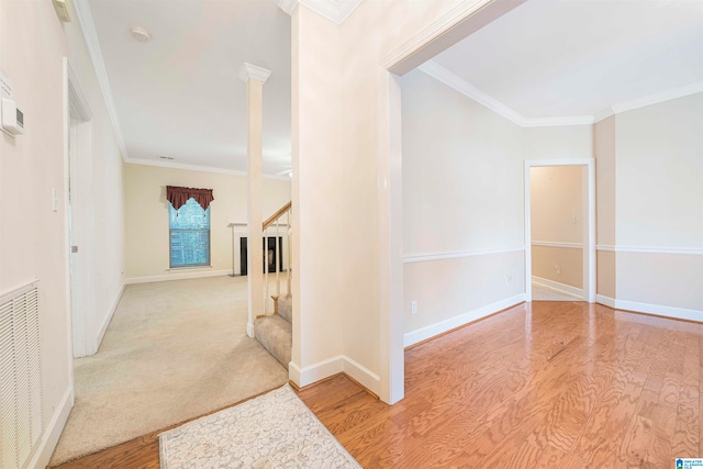 corridor with ornamental molding and light hardwood / wood-style floors