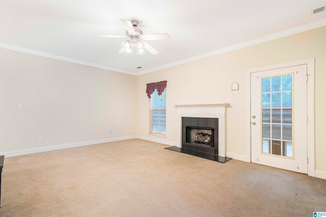 unfurnished living room featuring light colored carpet, ceiling fan, ornamental molding, and a tile fireplace