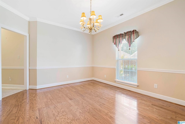 empty room with crown molding, a chandelier, and light hardwood / wood-style floors