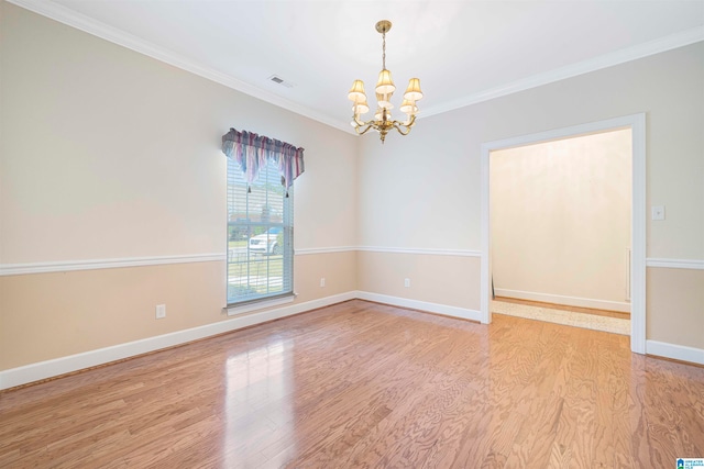 empty room with ornamental molding, light hardwood / wood-style flooring, and a chandelier