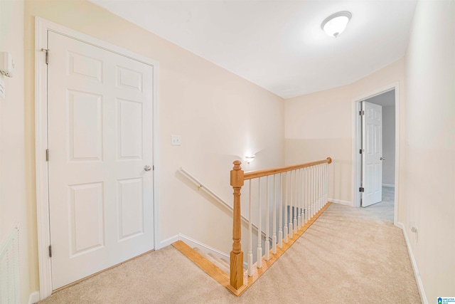 corridor featuring light colored carpet