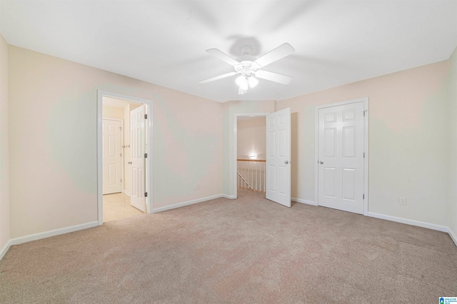 unfurnished bedroom with light colored carpet and ceiling fan