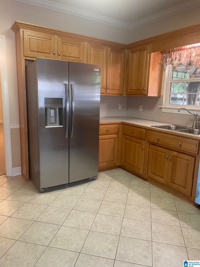 kitchen with stainless steel fridge with ice dispenser, light tile patterned floors, crown molding, and sink