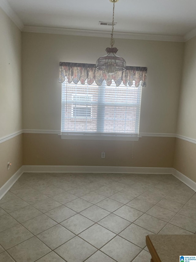 tiled empty room featuring a notable chandelier and ornamental molding