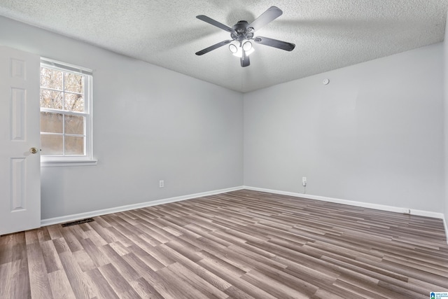 empty room featuring baseboards, light wood finished floors, visible vents, and a ceiling fan