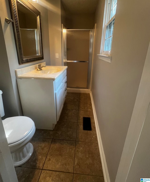 bathroom with tile patterned flooring, vanity, toilet, and walk in shower