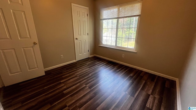 unfurnished bedroom featuring a closet and dark wood-type flooring