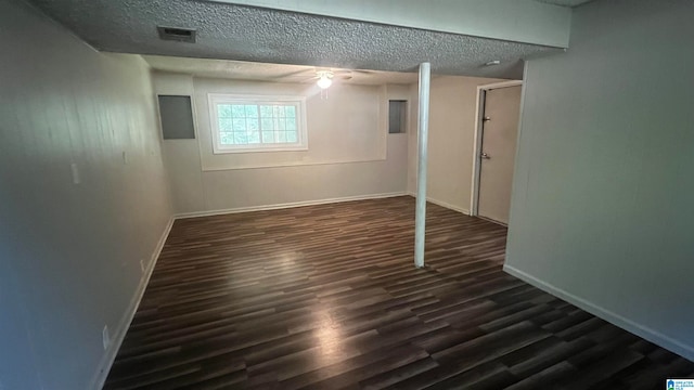 basement featuring dark hardwood / wood-style flooring and a textured ceiling