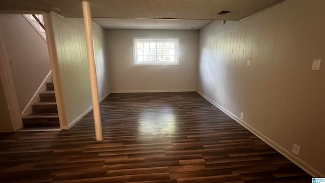 empty room featuring dark hardwood / wood-style floors and a textured ceiling