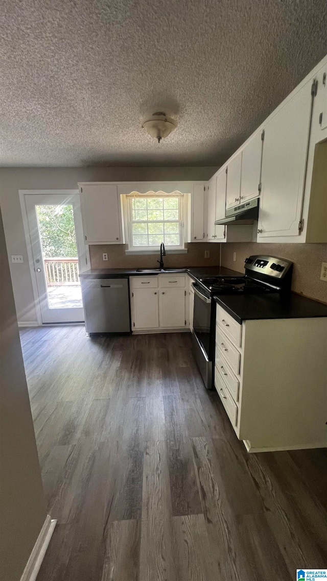 kitchen with sink, a textured ceiling, appliances with stainless steel finishes, dark hardwood / wood-style flooring, and white cabinetry