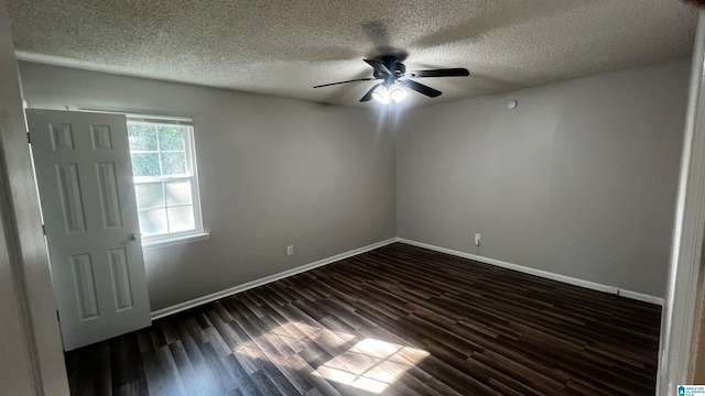 empty room with ceiling fan, dark hardwood / wood-style flooring, and a textured ceiling