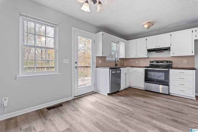 kitchen featuring visible vents, white cabinets, appliances with stainless steel finishes, under cabinet range hood, and a sink