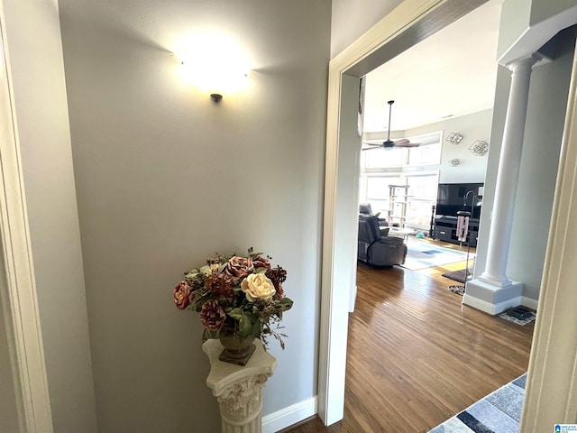 hall with hardwood / wood-style flooring and decorative columns