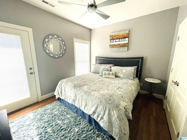 bedroom featuring dark wood-style floors, a ceiling fan, visible vents, and baseboards