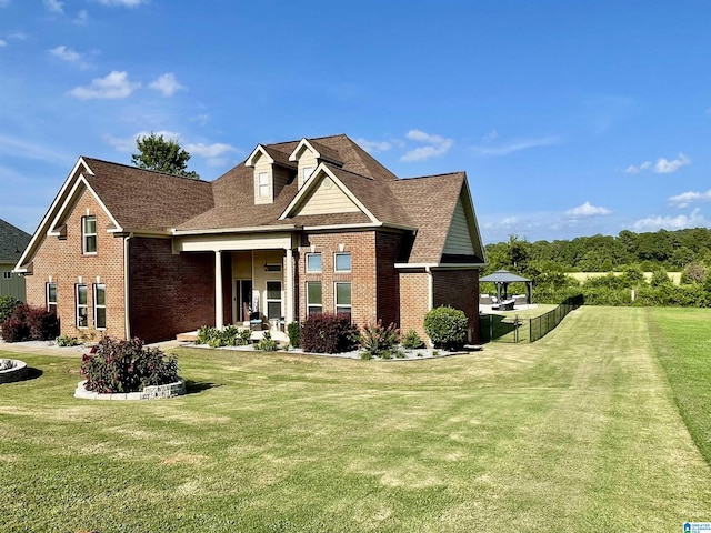 view of front of home with a front yard, brick siding, fence, and roof with shingles