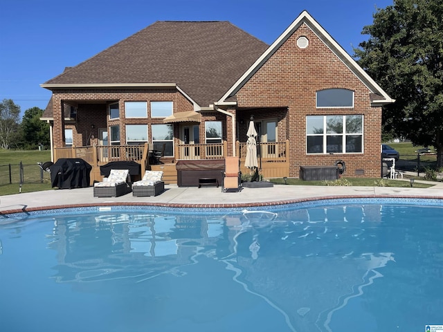 back of property featuring brick siding, fence, and a fenced in pool