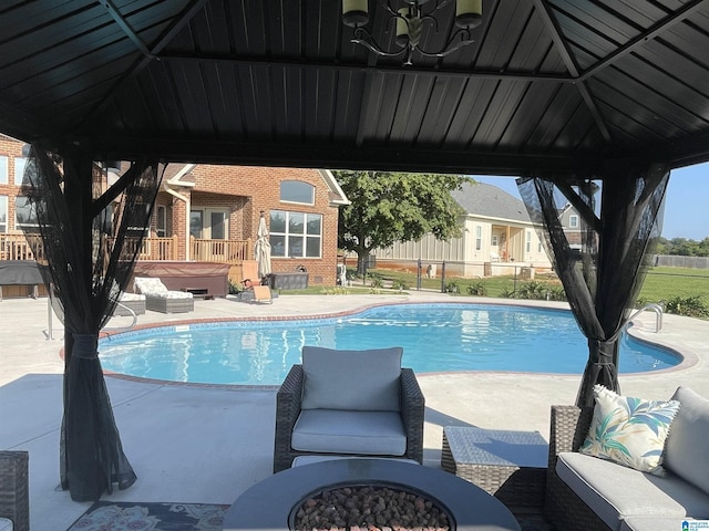 view of pool featuring a patio area, a hot tub, fence, and a gazebo