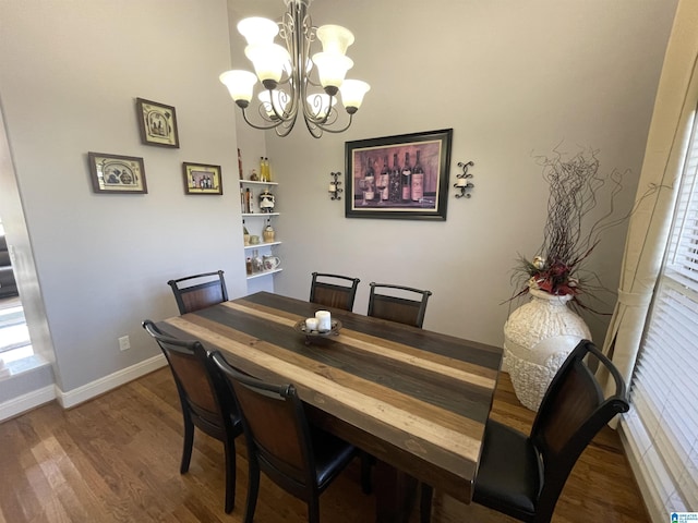 dining space with a notable chandelier, baseboards, and wood finished floors