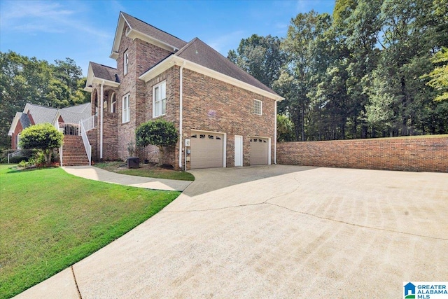 view of side of property featuring a garage and a lawn