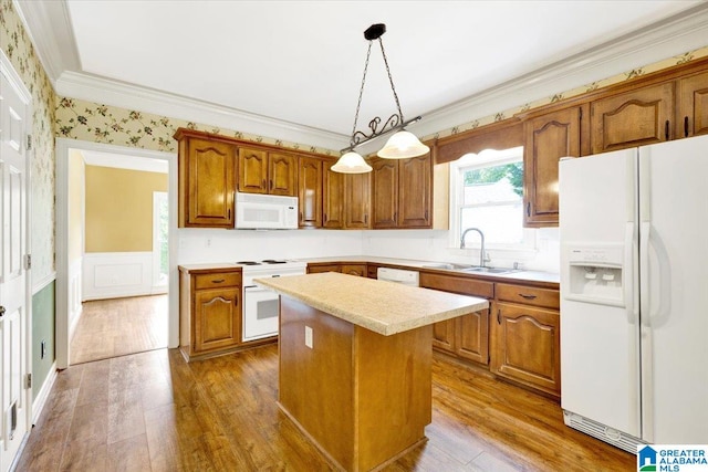 kitchen featuring hardwood / wood-style floors, white appliances, sink, decorative light fixtures, and a kitchen island