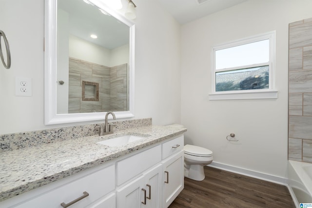 full bath with toilet, baseboards, wood finished floors, and vanity