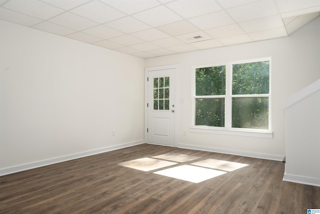 unfurnished room with dark wood-type flooring and a paneled ceiling