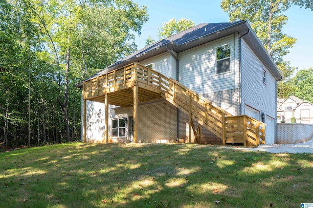 rear view of property with an attached garage, stairway, a lawn, and brick siding