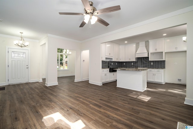 kitchen featuring white cabinets, custom exhaust hood, tasteful backsplash, dark countertops, and dark wood finished floors