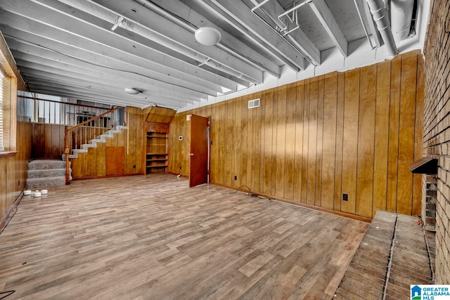 unfurnished living room with wooden walls and hardwood / wood-style floors