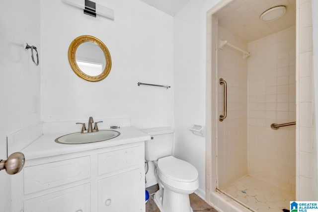 bathroom featuring vanity, tiled shower, and toilet