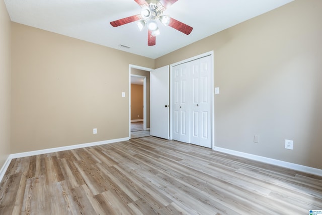 unfurnished bedroom featuring light hardwood / wood-style flooring, ceiling fan, and a closet