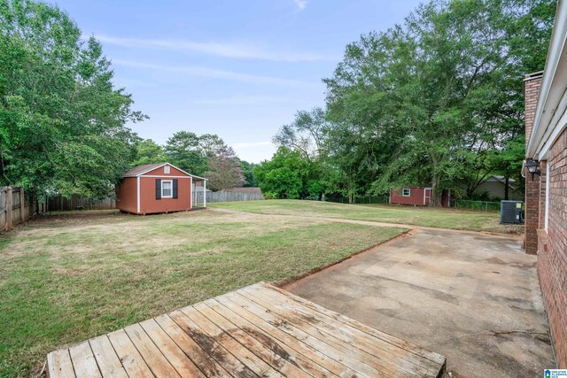 view of yard featuring a storage unit, central air condition unit, and a patio area