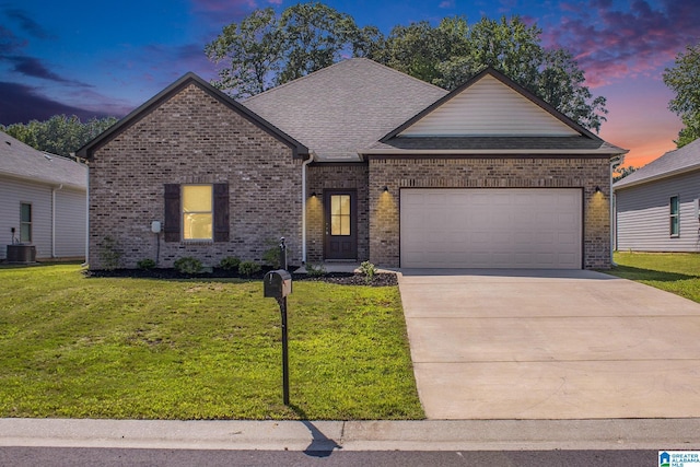 single story home with a garage, brick siding, a shingled roof, driveway, and a front yard