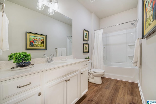 bathroom with vanity, wood finished floors, toilet, and shower / tub combo with curtain