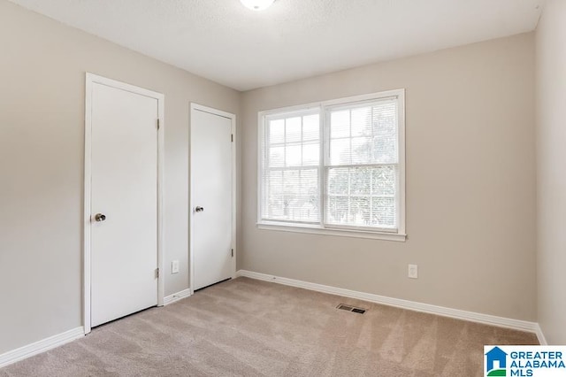 unfurnished bedroom featuring light colored carpet