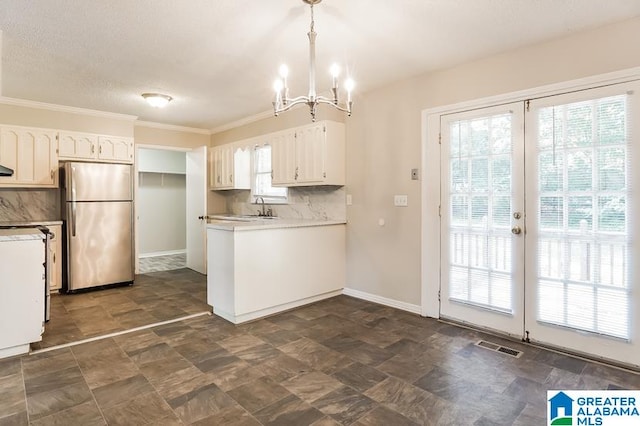 kitchen featuring dark tile patterned flooring, white cabinetry, stainless steel fridge, and tasteful backsplash