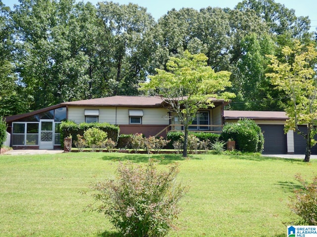 view of front facade featuring a garage, a front lawn, and a sunroom