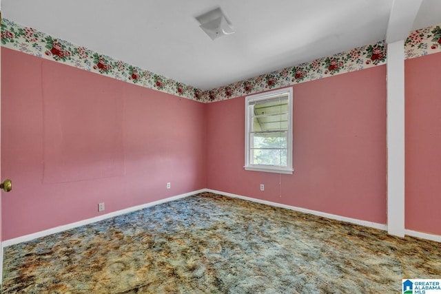 carpeted empty room featuring baseboards