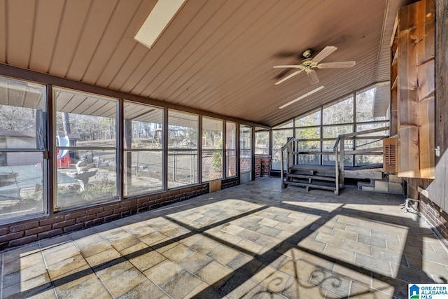 unfurnished sunroom featuring wood ceiling, vaulted ceiling, and a ceiling fan