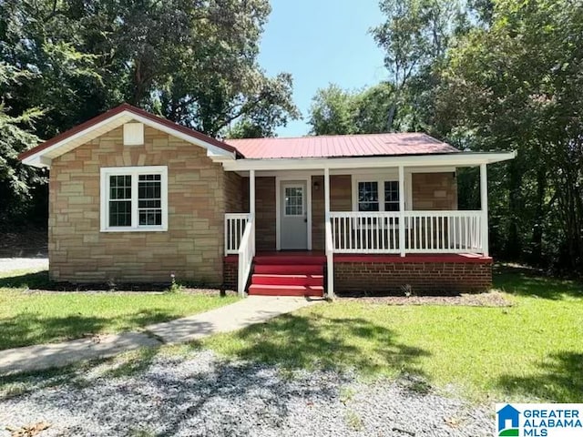 single story home featuring covered porch and a front yard