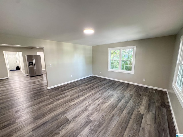 unfurnished room with dark wood finished floors and baseboards