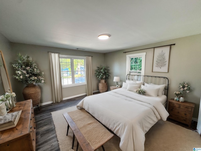 bedroom with visible vents, baseboards, and dark wood finished floors