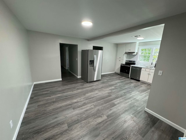 interior space with stainless steel appliances, hardwood / wood-style floors, backsplash, and white cabinetry