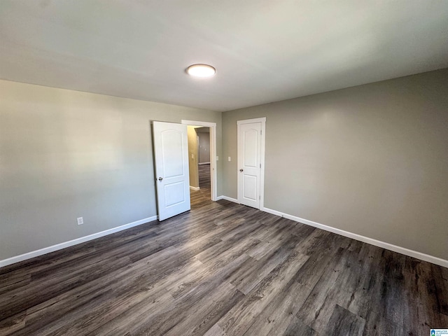 empty room with baseboards and dark wood-style flooring