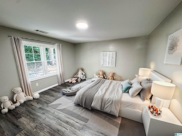 bedroom featuring baseboards, visible vents, and wood finished floors