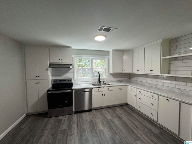 kitchen with dark hardwood / wood-style flooring, appliances with stainless steel finishes, sink, decorative backsplash, and white cabinets