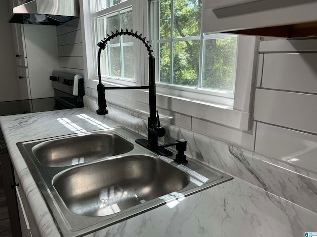 interior details featuring wall chimney exhaust hood and sink