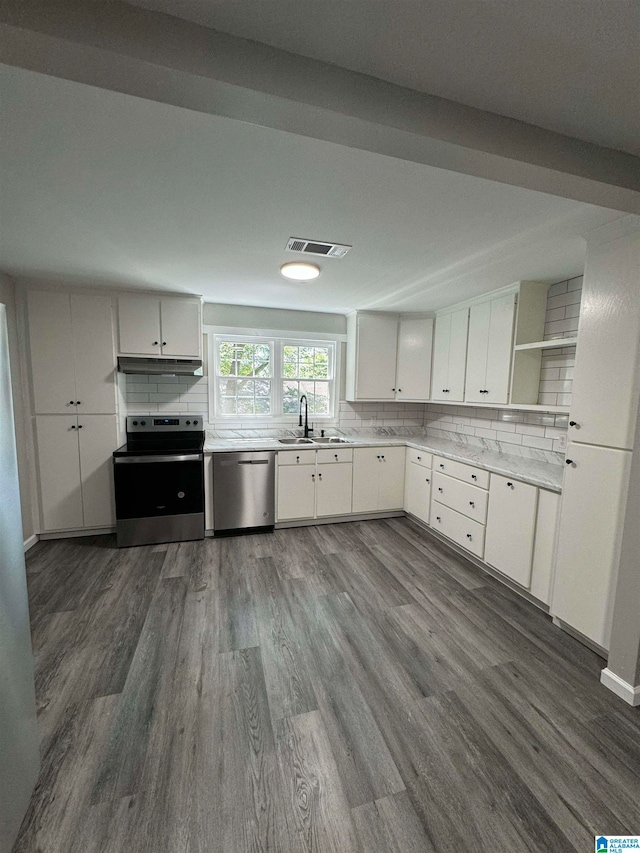 kitchen featuring appliances with stainless steel finishes, tasteful backsplash, sink, hardwood / wood-style flooring, and white cabinets